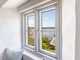 A window with a view of the water and buildings at 3 Glendale Cottages Dittisham near Dartmouth