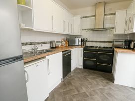 A kitchen with refrigerator, sink, and cooking range at Preswylfa, Caernarfon