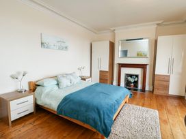 A bedroom with a bed, bedside tables, and wardrobes at Preswylfa in Caernarfon