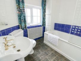 A bathroom with a bath tub, toilet, and sink at Preswylfa in Caernarfon