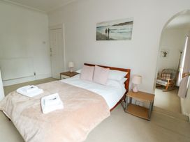 A bedroom with a bed and a painting at Preswylfa, Caernarfon
