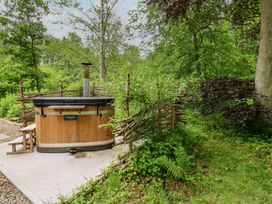 A hot tub surrounded by plants and a wooden fence at Bracken Fern in Eppleby