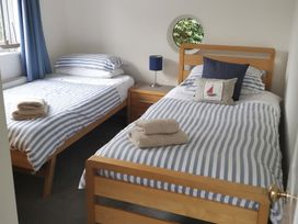 A bedroom with two beds and a window at Hawthorn Cottage in St Teath
