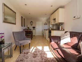 A living room with a sofa and dining table at Cartwheel Cottage in Yearsley