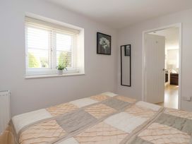 A bedroom with a bed and window at Cartwheel Cottage in Yearsley