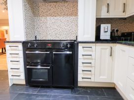 A kitchen with a range cooker and cabinets at Arosfa Axton near Trelawynd
