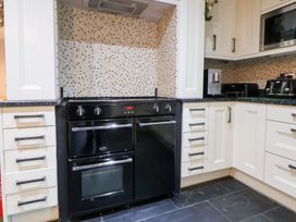 A kitchen with a black oven and countertop at Arosfa Axton near Trelawynd