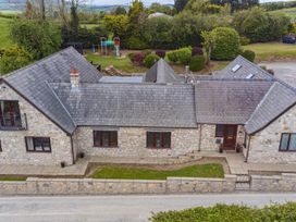 An aerial view of a house with a patio and garden at Arosfa in Axton near Trelawynd