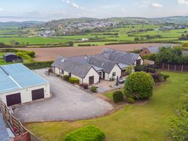 An aerial view of a house with garden and fields at Arosfa in Axton near Trelawynd