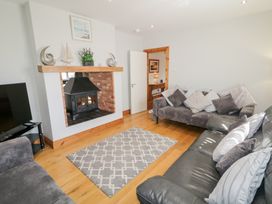 A living room with two sofas a rug a fireplace and a television at SeaShells in Castlerock