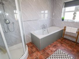 A bathroom with a shower enclosure bathtub towel rack with towels and a window with decor at SeaShells in Castlerock