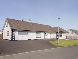 A single story house with a garage driveway and grass lawn at SeaShells in Castlerock