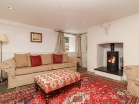 A living room with a sofa and fireplace at Old Maids Cottage in Woolacombe