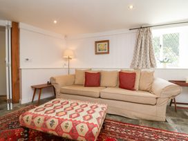 A living room with a sofa and ottoman at Old Maids Cottage Woolacombe