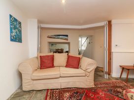 A living room with a sofa and dining table at Old Maids Cottage in Woolacombe