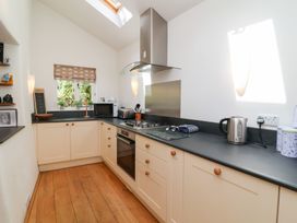 A kitchen with a stove and microwave at Old Maids Cottage in Woolacombe
