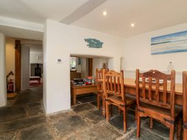 A dining room with a wooden table and chairs at Old Maids Cottage Woolacombe