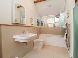 A bathroom with a sink, toilet, and bath tub at Old Maids Cottage in Woolacombe