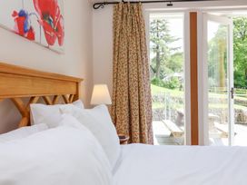 A bedroom with a bed and curtains at Old Maids Cottage in Woolacombe