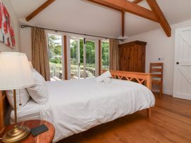 A bedroom with a bed and wardrobe at Old Maids Cottage in Woolacombe