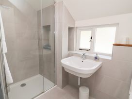 A bathroom with a shower and wash basin at Old Maids Cottage in Woolacombe