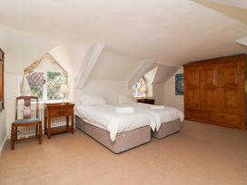 A bedroom with two beds and a wardrobe at Old Maids Cottage in Woolacombe