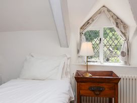 A bed with a lamp and window in a bedroom at Old Maids Cottage in Woolacombe