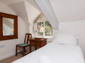 A bedroom with a bed, desk, and chair at Old Maids Cottage in Woolacombe