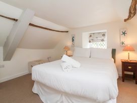 A bedroom with a bed and a bedside table at Old Maids Cottage in Woolacombe