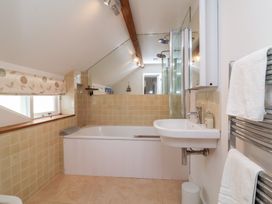 A bathroom with a bathtub and sink at Old Maids Cottage in Woolacombe