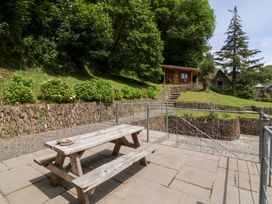 An outdoor area with a picnic table and stone wall at Old Maids Cottage in Woolacombe