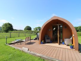 A cabin with a deck and chairs at Bwthyn Bach Brefi