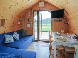 A seating area with a sofa and dining table at Bwthyn Bach Brefi