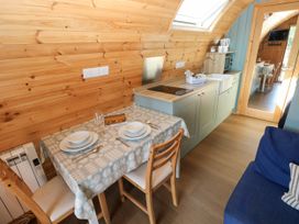 A kitchen with a dining table and chairs at Bwthyn Bach Brefi in Llanddewi-Brefi
