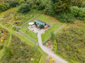 A green cabin with outdoor seating at Onnen in Oakford near Aberaeron