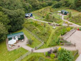 An outdoor area with cabins and garden paths at Onnen Oakford near Aberaeron