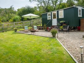 An outdoor area with a green shed and seating at Onnen Oakford near Aberaeron