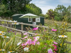 An outdoor scene with a shepherd's hut and flowers at Onnen Oakford near Aberaeron