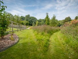 A garden pathway surrounded by grass and trees at Onnen in Oakford near Aberaeron