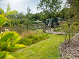 A garden with a shed, gate and pathway at Onnen in Oakford near Aberaeron
