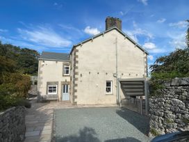 A house with a bench and carport at Victoria Mount in Grange-Over-Sands