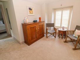 A sitting room with a cabinet and chairs at 21 Alverton Street Penzance