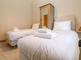 A bedroom with two beds and a wardrobe at 21 Alverton Street in Penzance