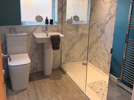 A bathroom featuring a toilet, sink, and shower at Honeybees Haven in Hunstanton