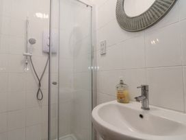 A bathroom with a shower enclosure and a sink with liquid soap at Royal Victoria House in Scarborough