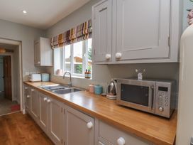A kitchen with a sink and microwave at 21 Eskdaleside in Sleights