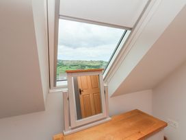 A bedroom with a mirror and a window showing a landscape at 21 Eskdaleside Sleights