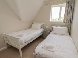 A bedroom with two single beds and a window at 21 Eskdaleside Sleights