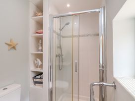 A shower with a toilet and shelf in a bathroom at 21 Eskdaleside Sleights