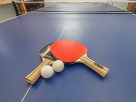 A table tennis setup with paddles and balls at a sports facility